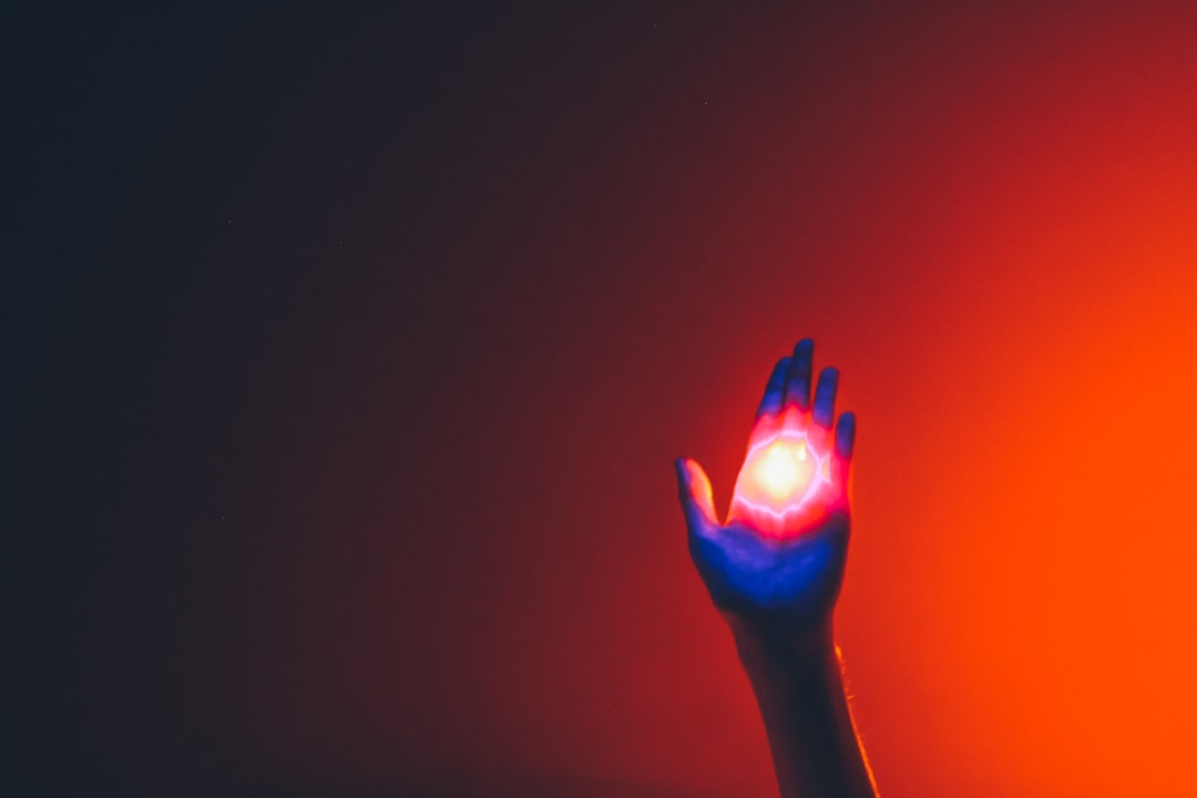 Futuristic medical AI interface showing error warning with human hand reaching to intervene, dramatic red and amber lighting, ethical dilemma visualization, clean modern hospital setting