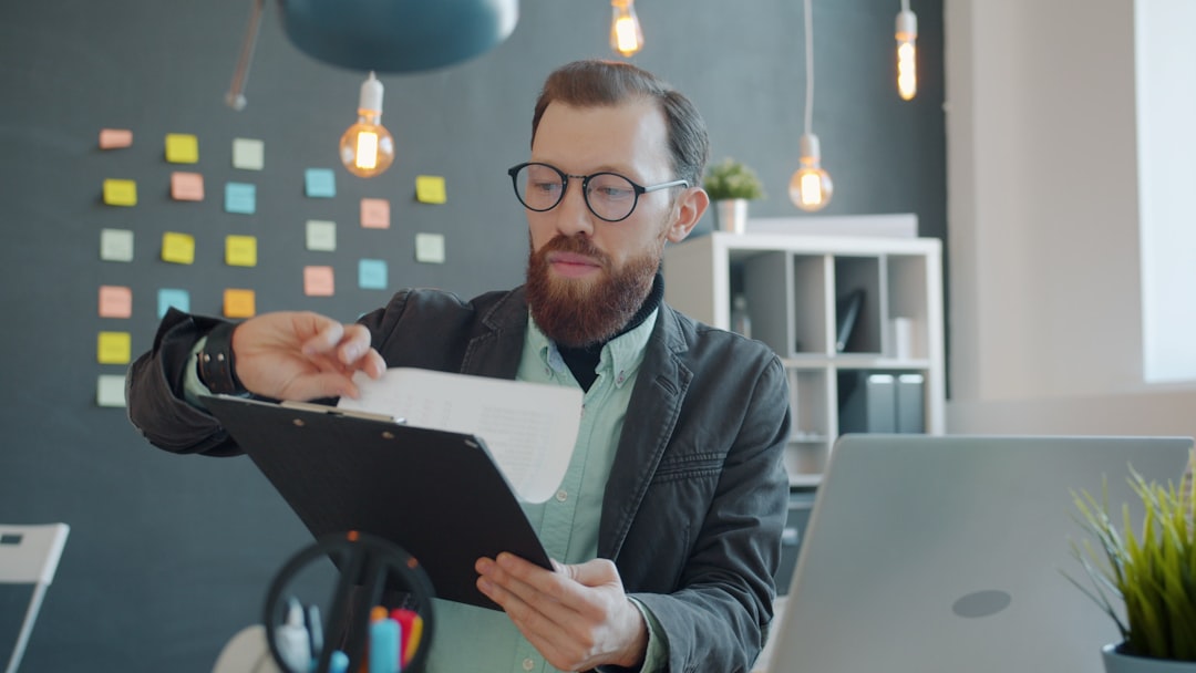 Business executive examining holographic financial data and microchip details in clean modern office, warm golden ambient lighting, abstract visualization of transformed capital flows