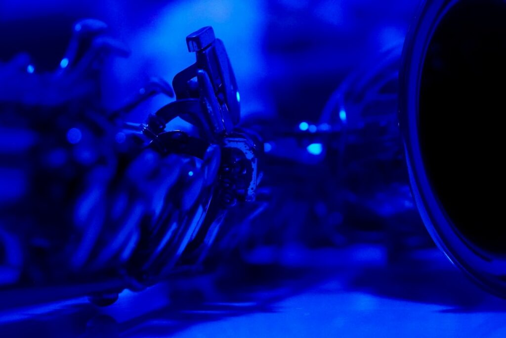 Futuristic abstract neural network visualization morphing into physical robotic arm, sleek ambient blue lighting, clean modern tech lab, human hand reaching toward machine collaboration