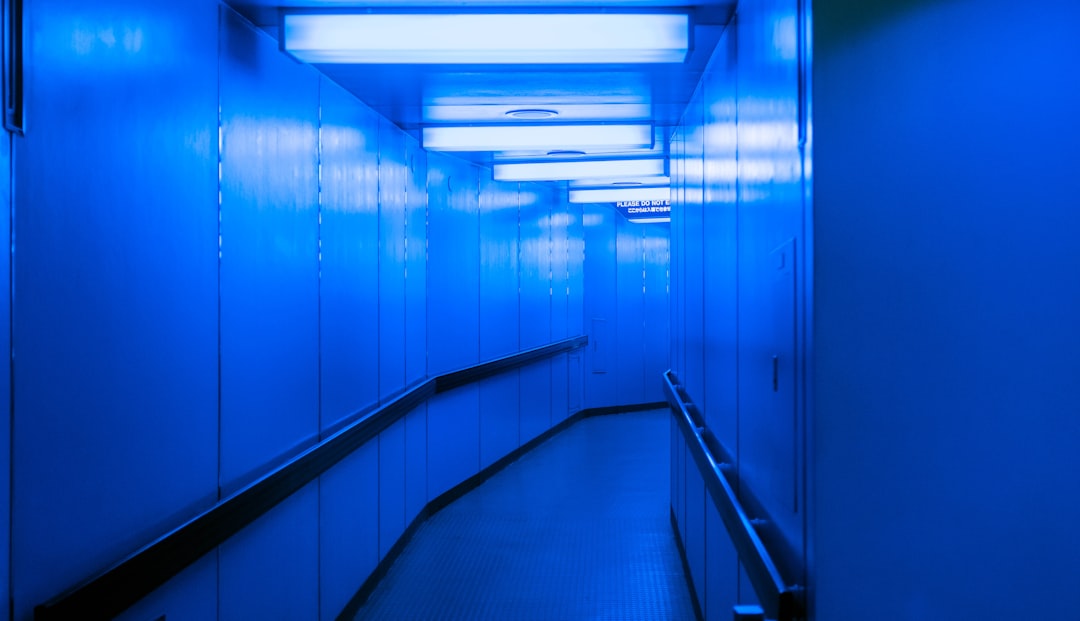 Massive GPU server room with ethereal blue-green light trails, monk in simple robe walking between server racks, data center atmosphere, spiritual and technological fusion, cinematic ambient lighting,