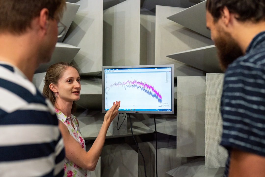Diverse group of educators and engineers collaborating around curved holographic display showing adaptive learning pathways, futuristic university lab, soft natural light mixed with LED panels, human-