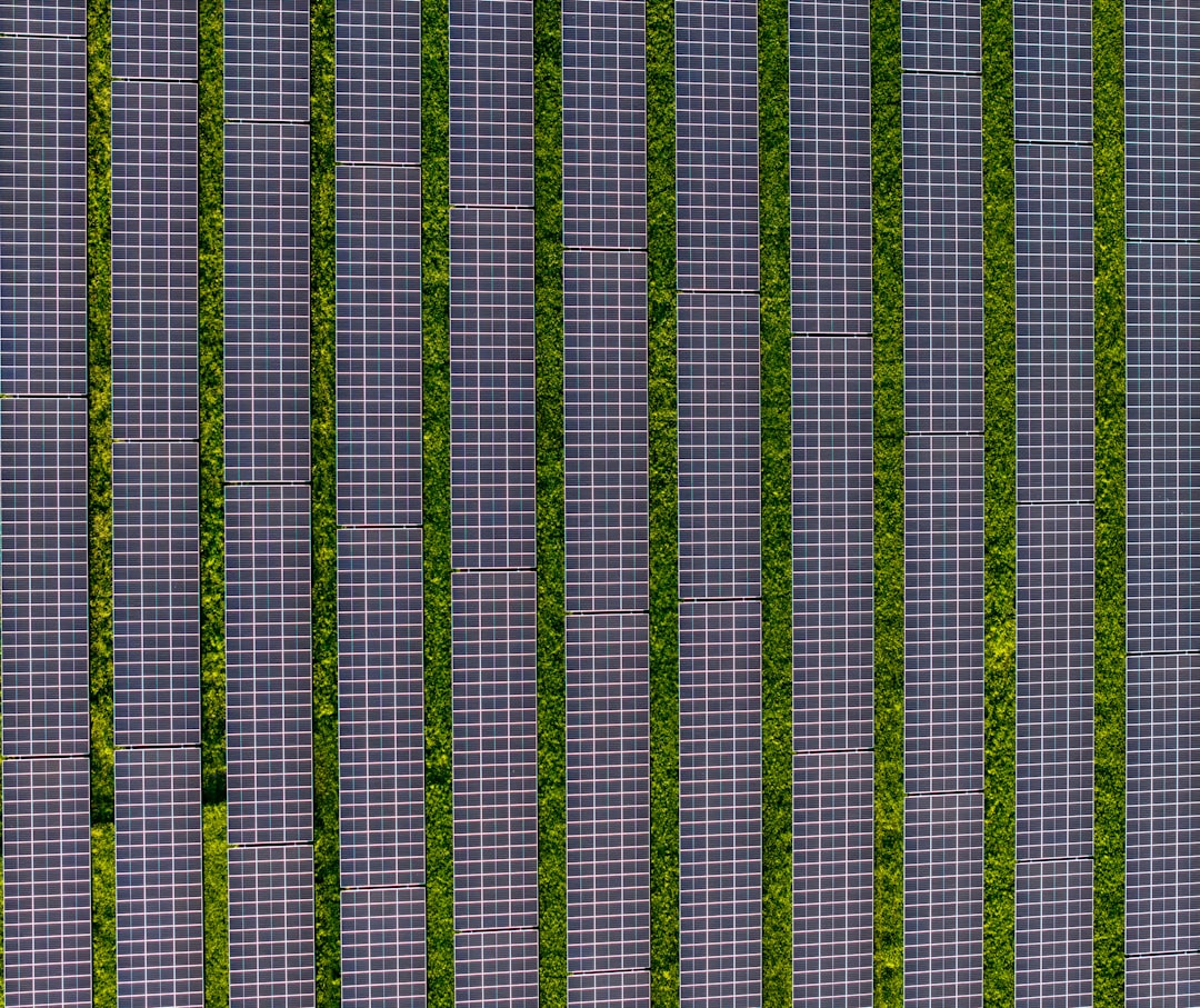 Sustainable energy grid visualization with solar panels and wind turbines merging with digital network, green and blue holographic overlay, professional clean aesthetic, futuristic power infrastructur