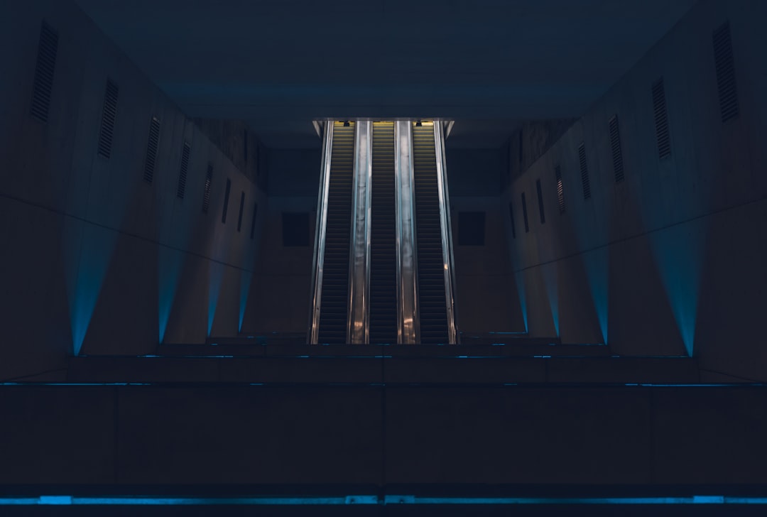 Futuristic courthouse interior with holographic legal documents floating above sleek wooden bench, ambient blue lighting, professional judge silhouette examining AI-generated case analytics on transpa